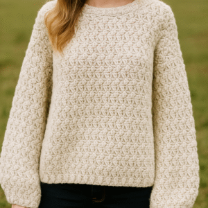 Woman wearing a cream-colored sweater made with the Oversized Bulky Sway Crochet Sweater Pattern, featuring a textured, chunky stitch design and long, loose sleeves.