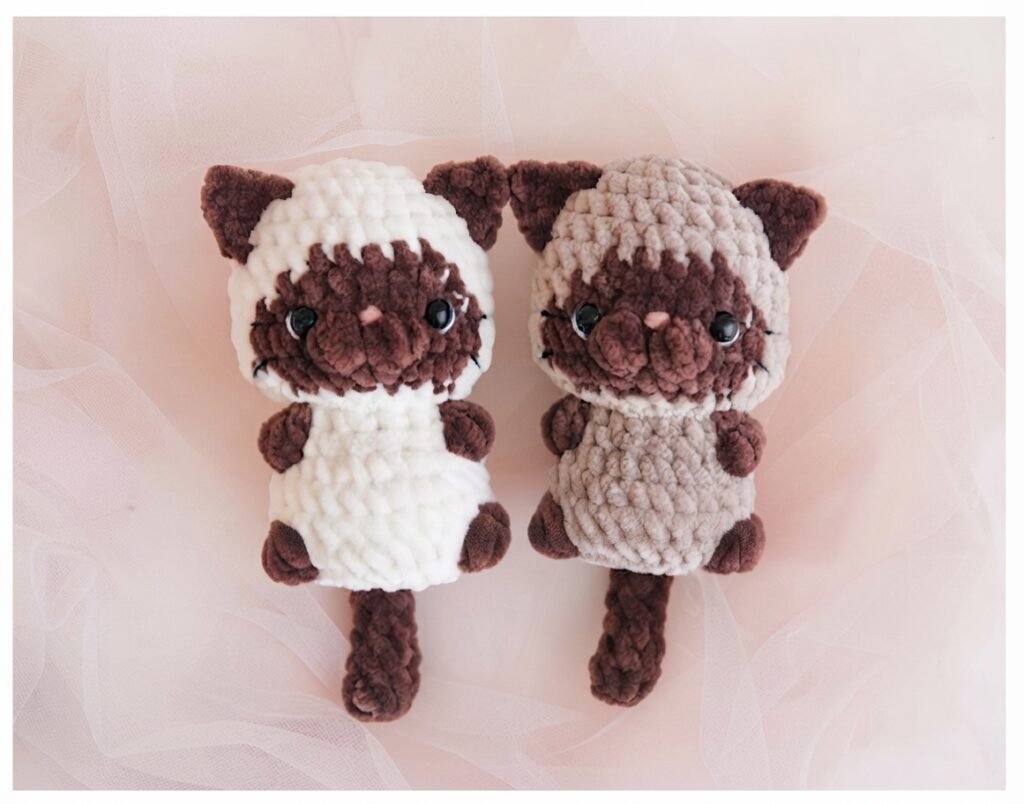 Two handmade Siamese-style plush crochet cats with dark brown points, showcasing inspiration from Free Amigurumi Baby Cats Crochet Patterns.